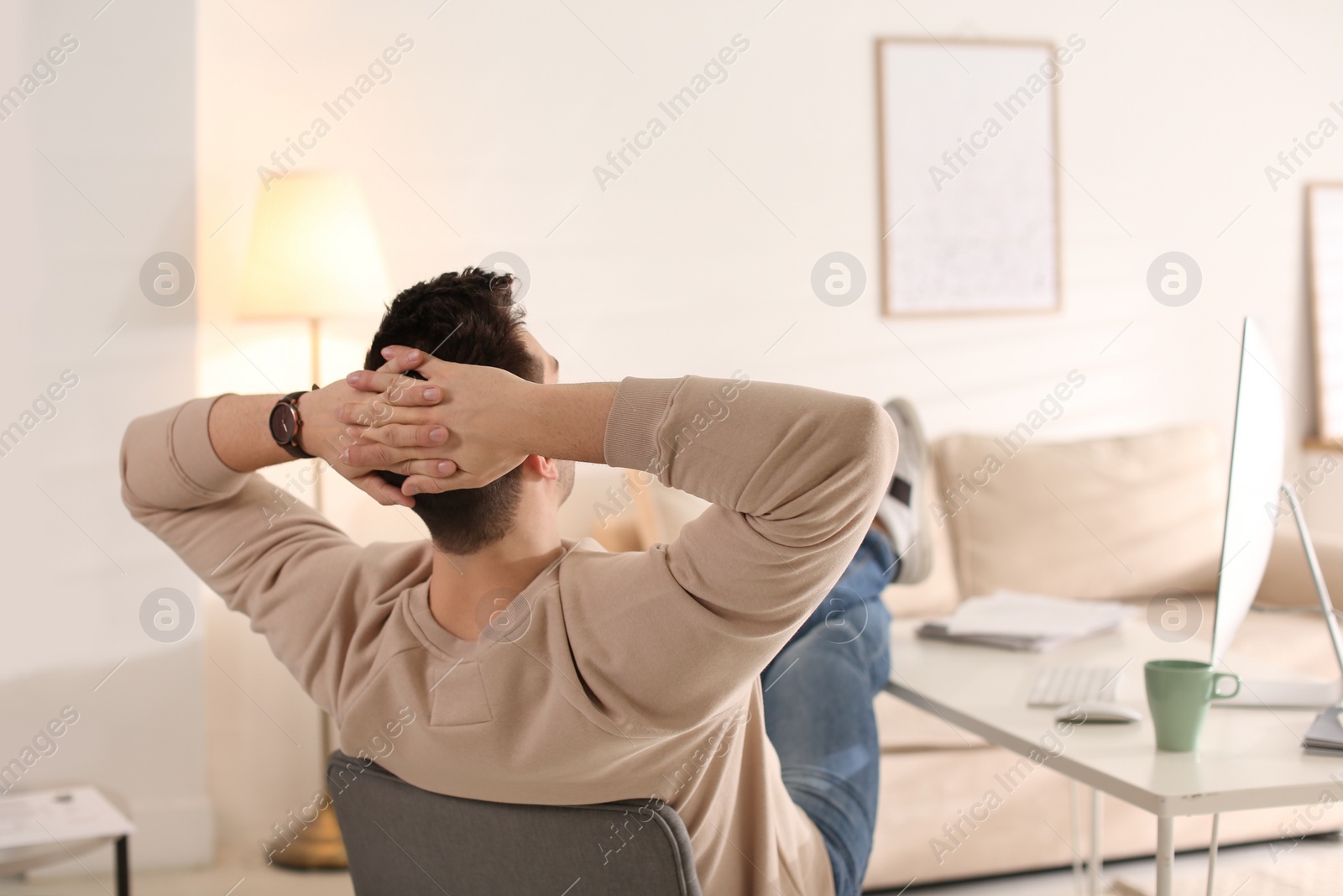 Photo of Young man relaxing at table in office during break