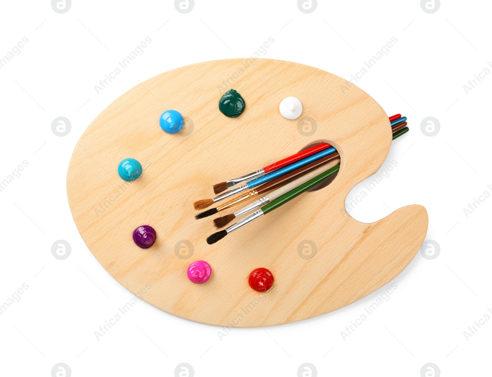 Photo of Wooden artist's palette with brushes and samples of paints isolated on white, top view