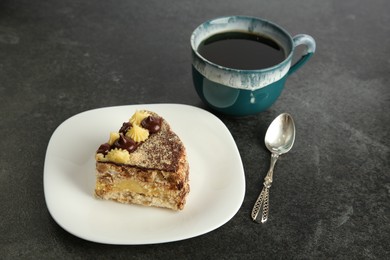 Photo of Piece of delicious Kyiv Cake served with coffee on black table