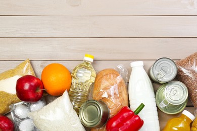 Photo of Different donation food on wooden table, flat lay. Space for text