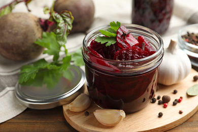 Delicious pickled beets and spices on wooden table