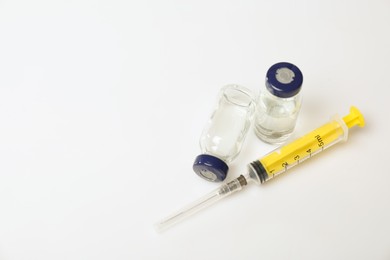 Photo of Syringe and vials on white background, above view. Space for text