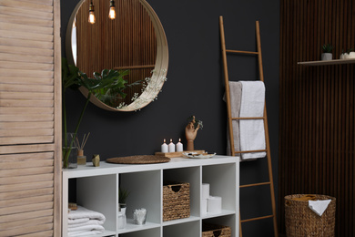 Photo of Elegant modern bathroom with mirror on black wall