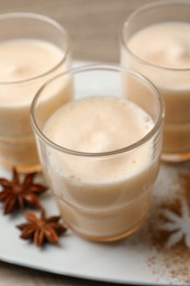 Photo of Delicious eggnog with anise on wooden table