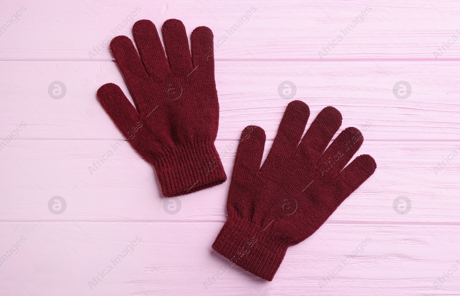 Photo of Stylish gloves on pink wooden background, flat lay