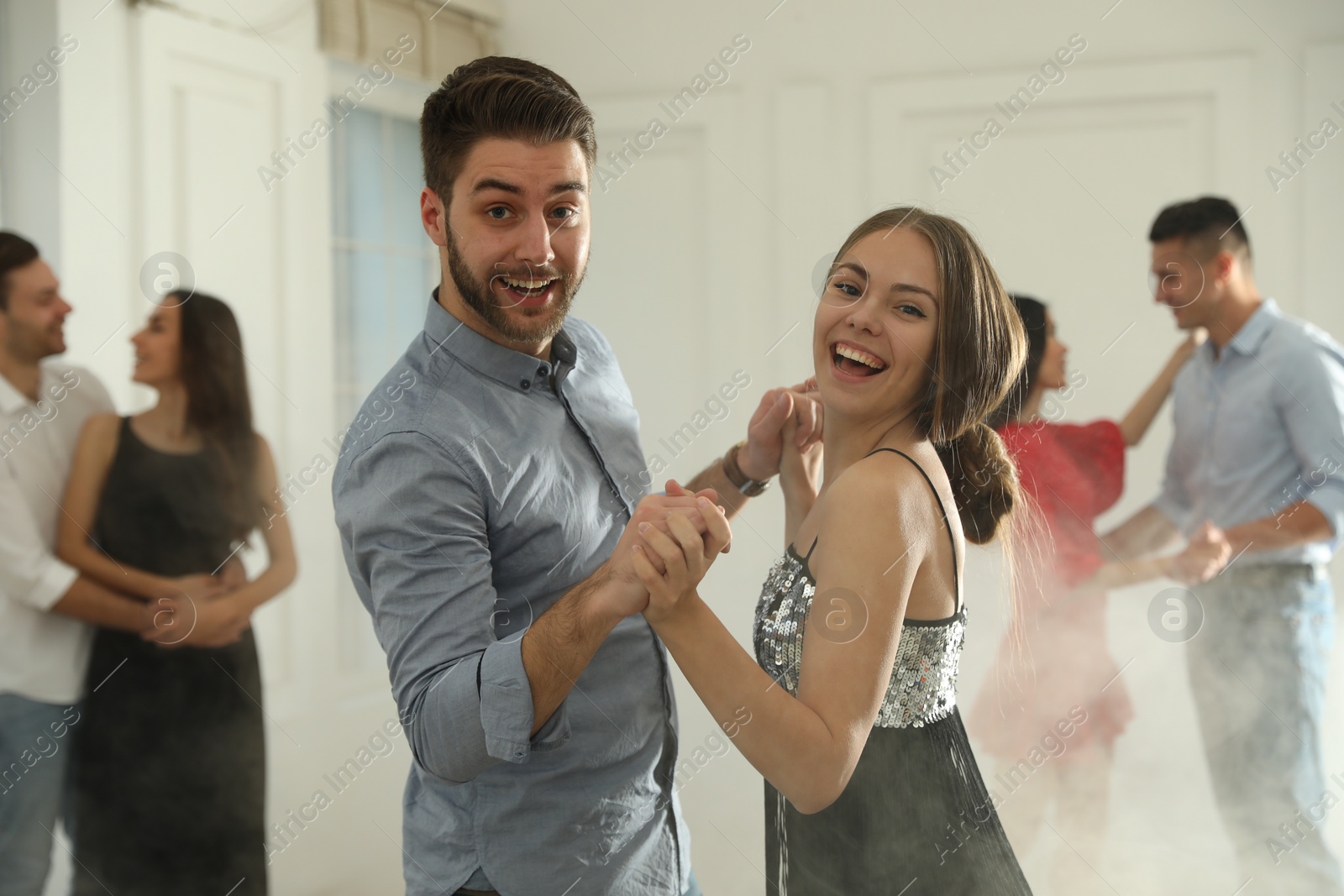 Photo of Lovely young couple dancing together at party