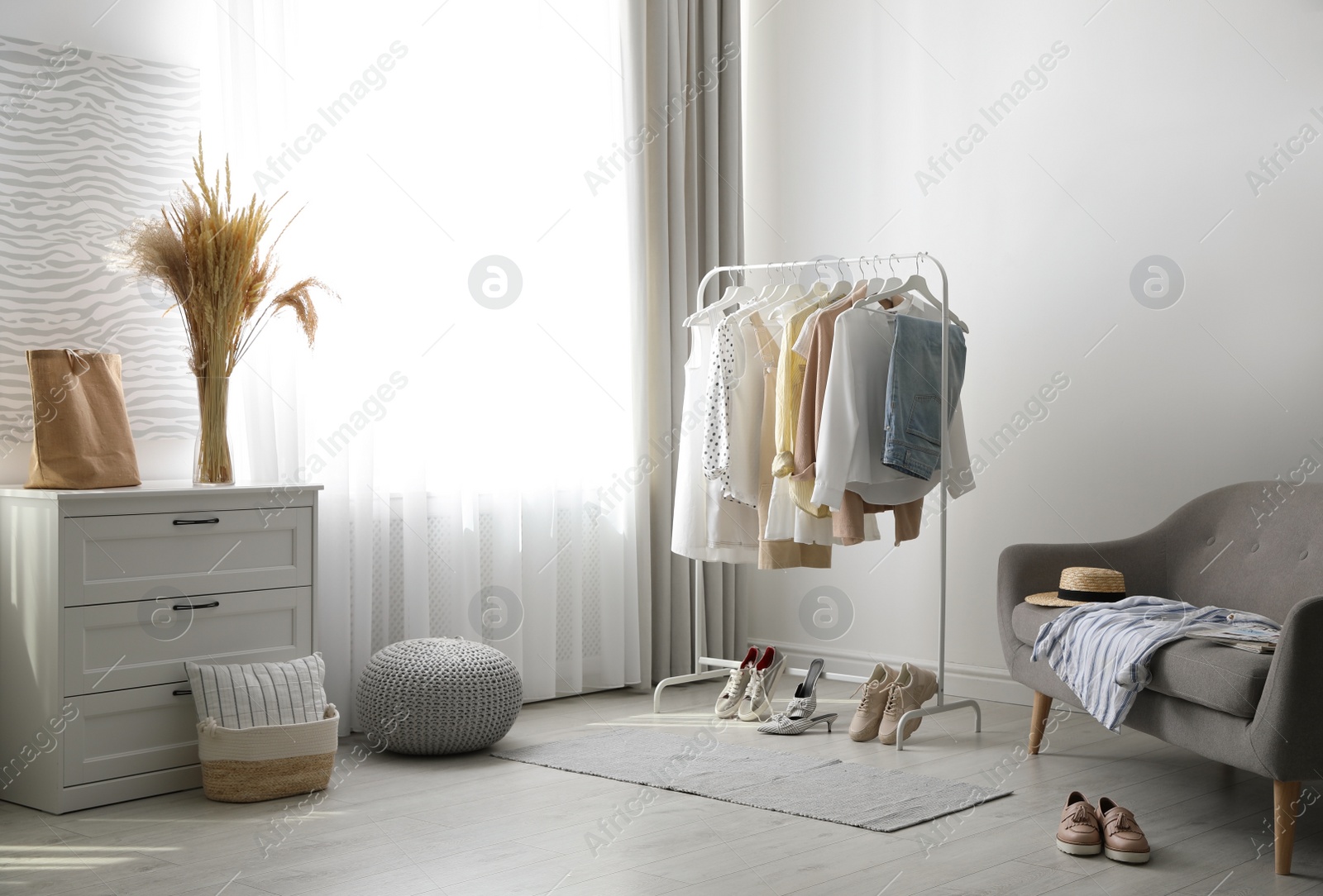 Photo of Dressing room interior with clothing rack and sofa