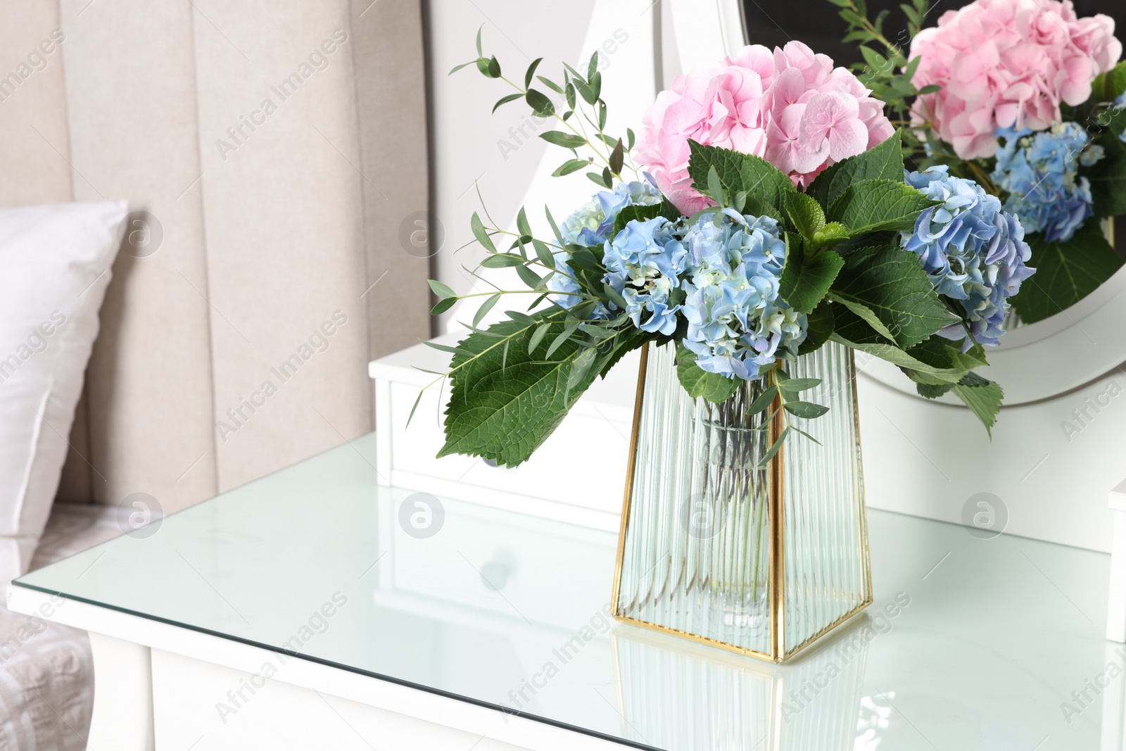 Photo of Beautiful hortensia flowers in vase on dressing table indoors. Space for text