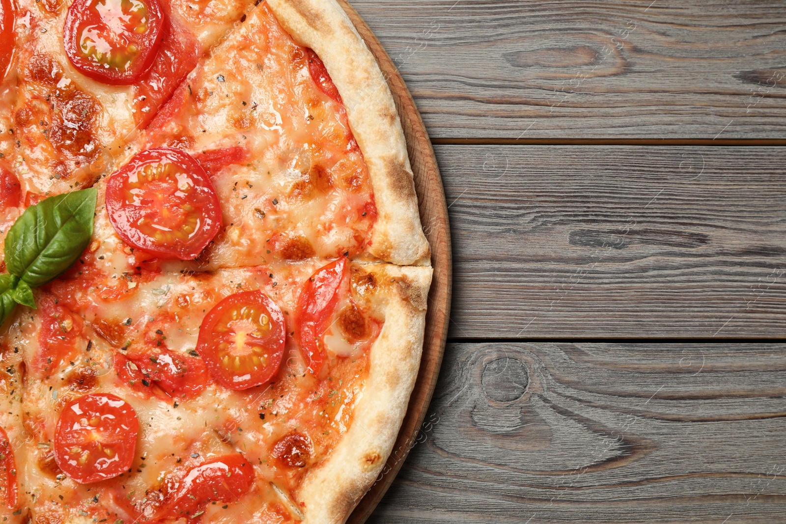 Photo of Delicious pizza Margherita on wooden table, top view. Space for text