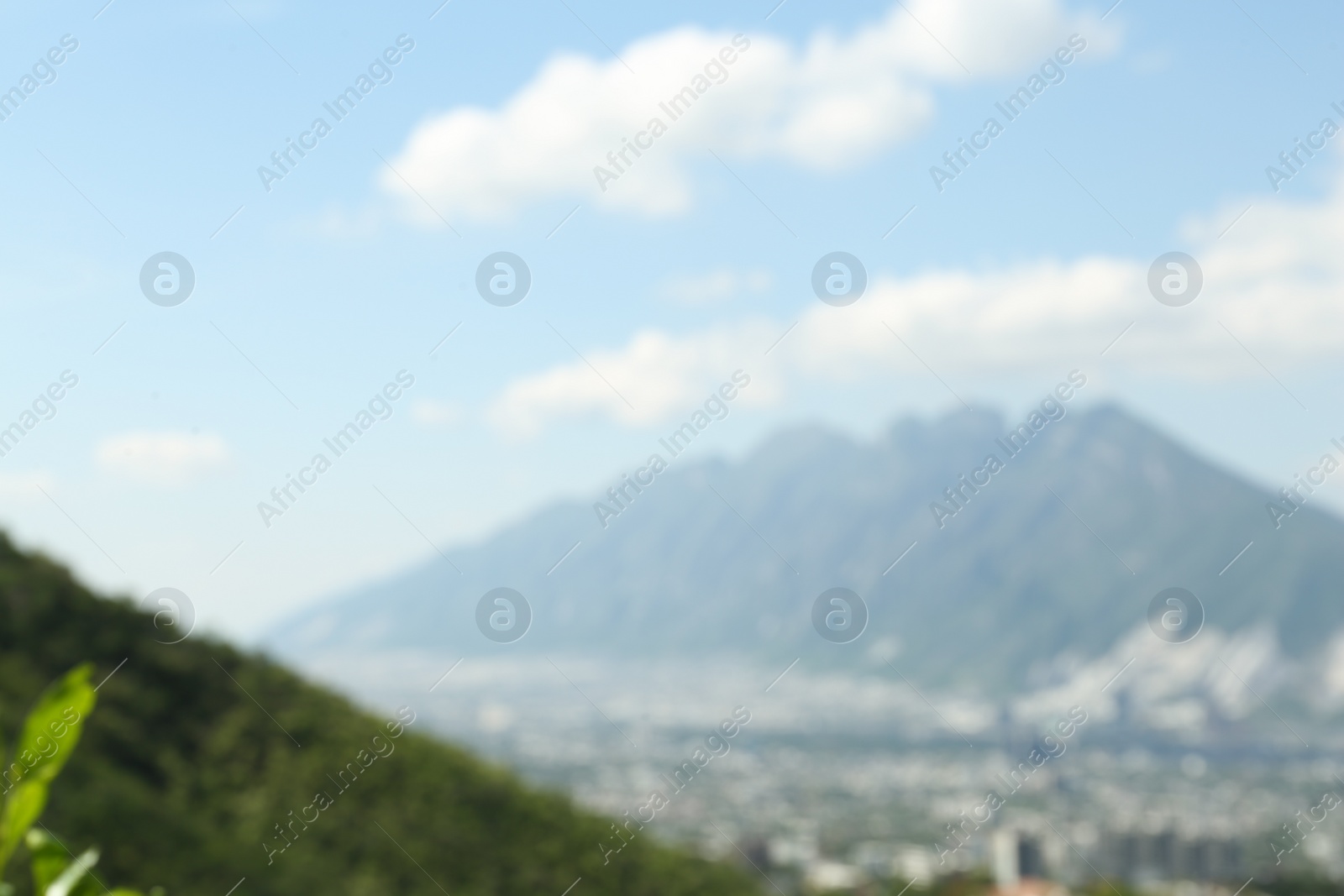 Photo of Blurred view of city with mountains under beautiful sky