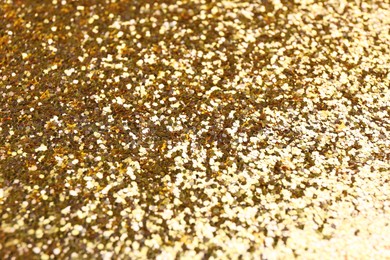 Shiny bright golden glitter as background, closeup