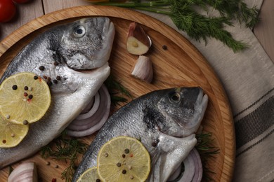 Photo of Raw dorado fish, lemon and spices on table, flat lay