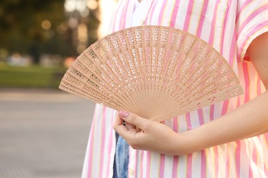 Photo of Woman with hand fan outdoors, closeup view