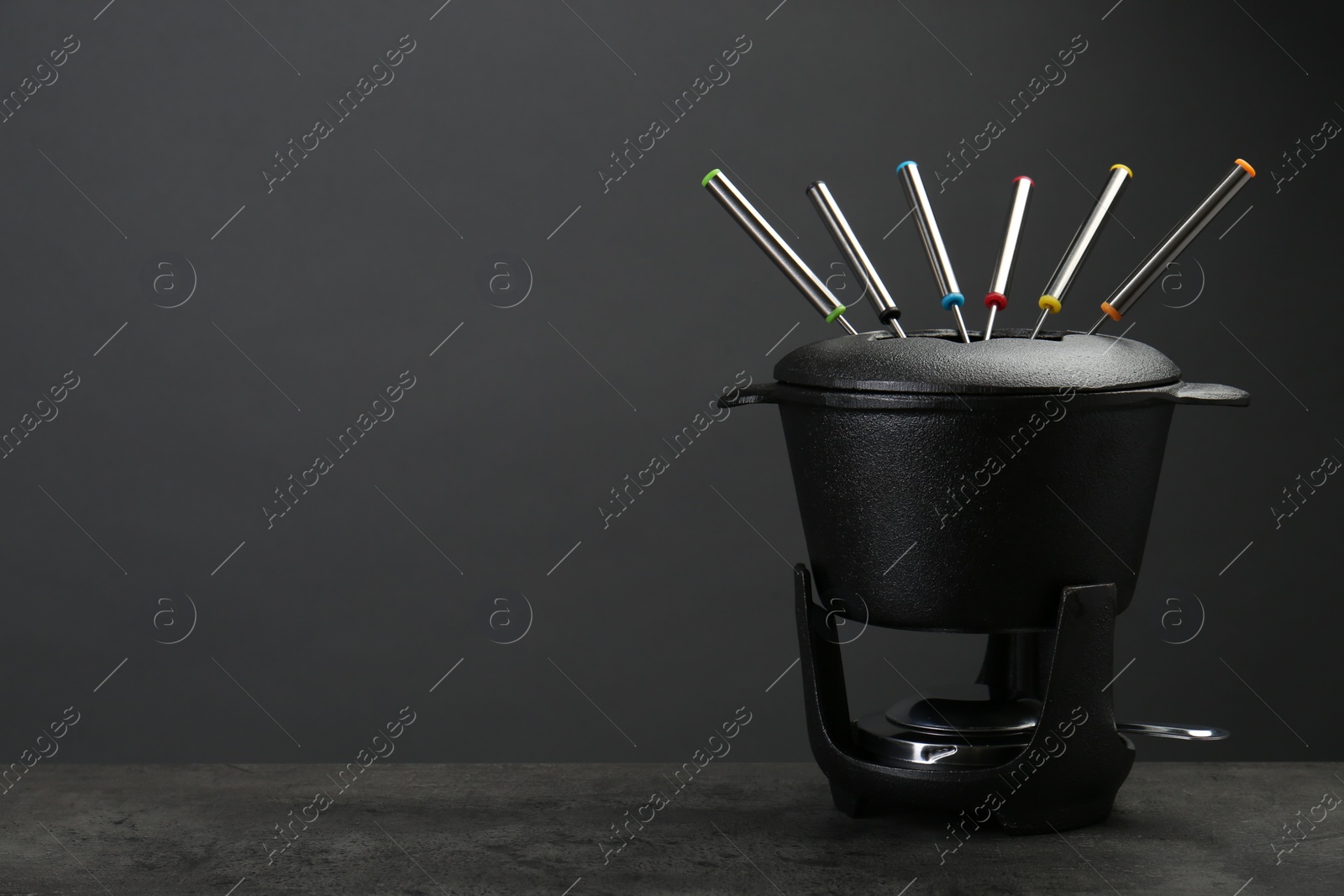 Photo of Fondue set on grey textured table, space for text