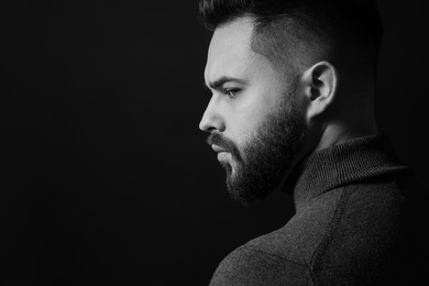 Photo of Portrait of handsome bearded man on dark background, space for text. Black and white effect