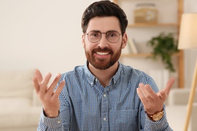 Happy man having video call at home, view from web camera