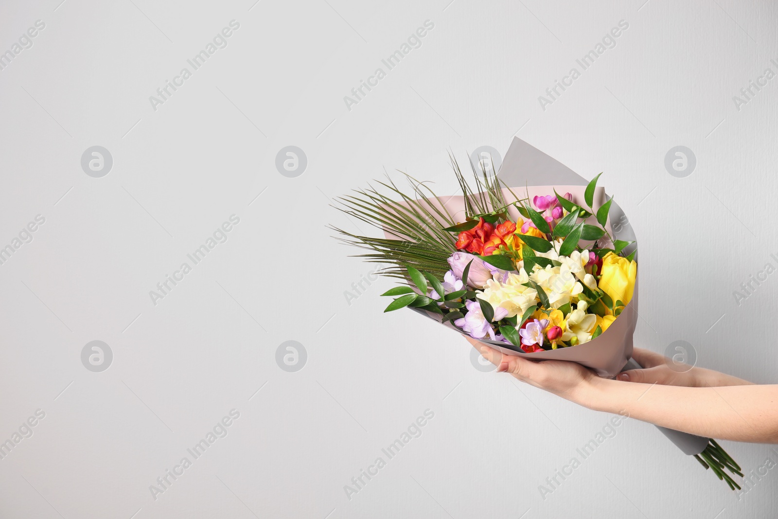 Photo of Woman with beautiful bouquet of freesia flowers on white background