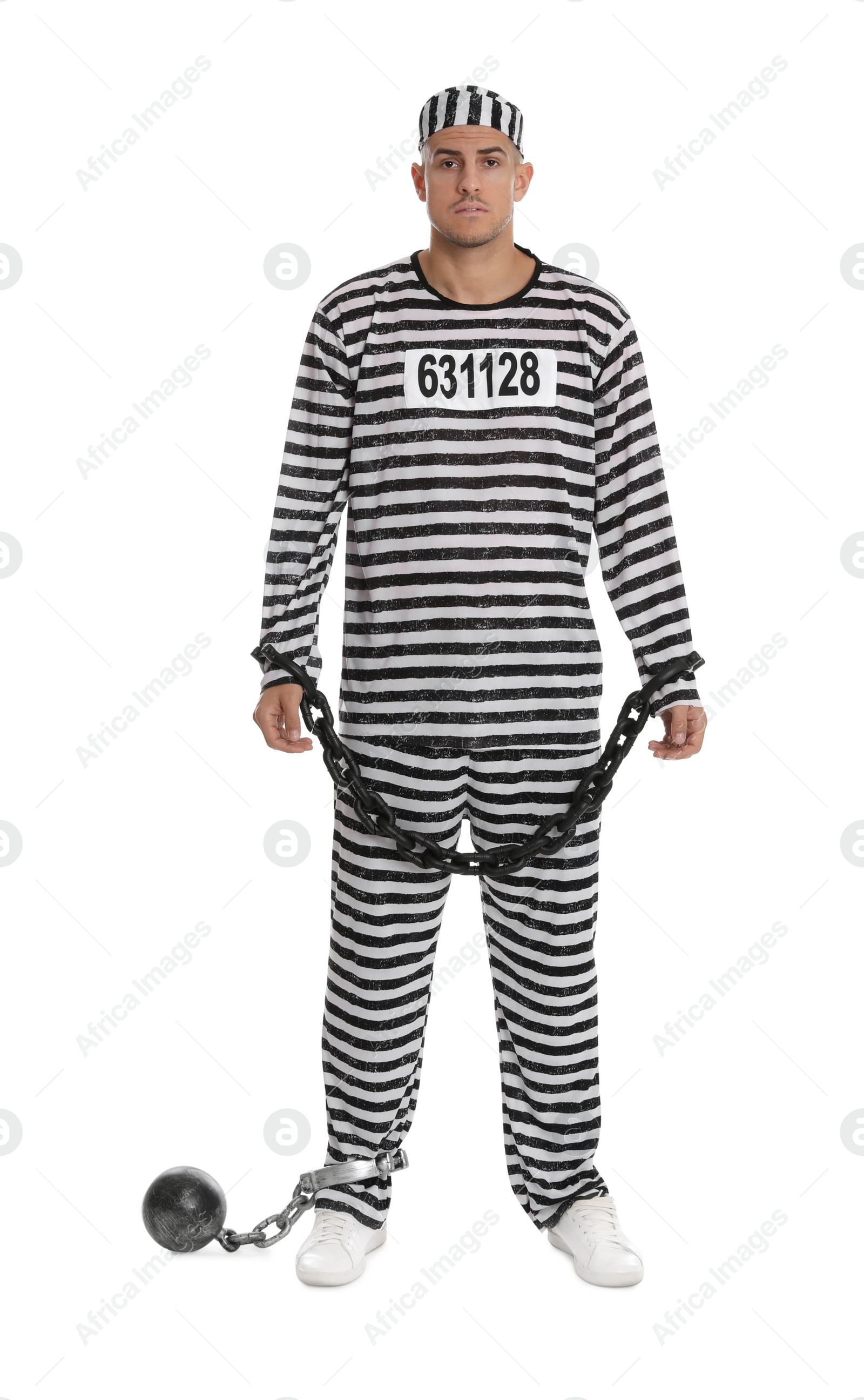 Photo of Prisoner in striped uniform with chained hands and metal ball on white background