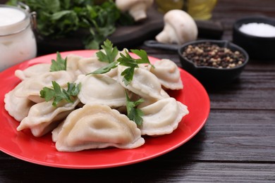 Delicious dumplings (varenyky) with potatoes and parsley served on brown wooden table