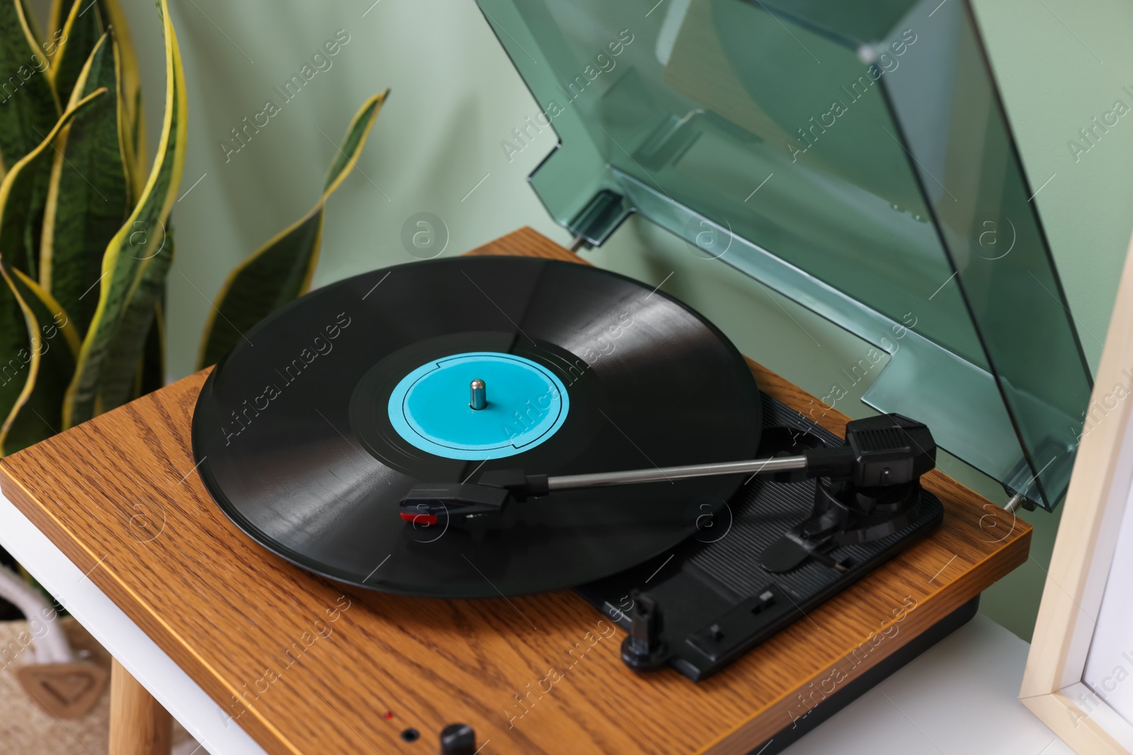 Photo of Stylish turntable with vinyl record indoors, above view