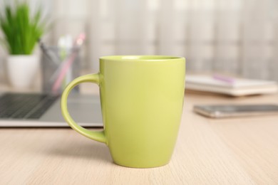 Photo of Mug of hot drink on wooden table in office. Coffee Break
