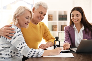 Female notary working with mature couple in office