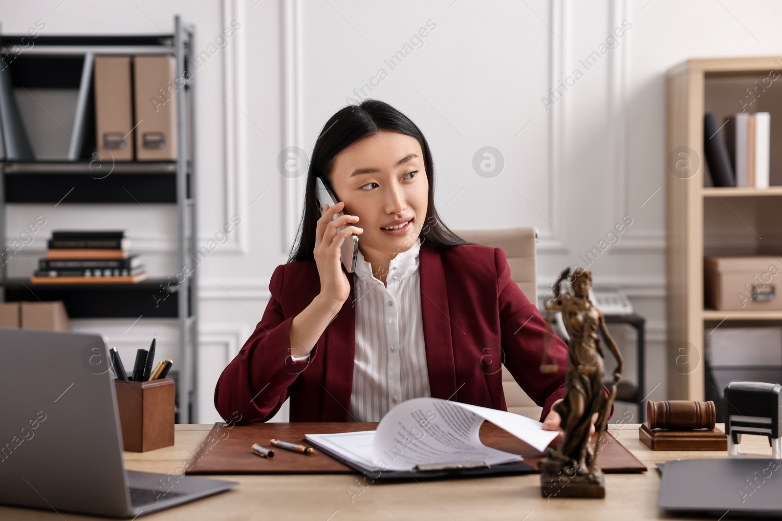 Photo of Notary talking on phone at table in office