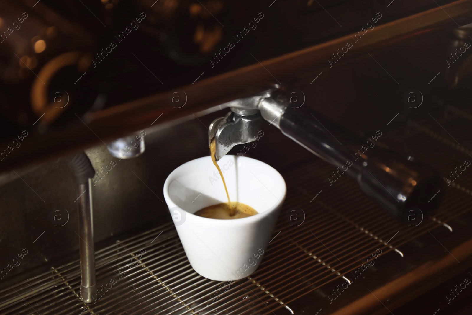 Photo of Preparing fresh aromatic coffee on modern machine, closeup