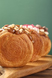 Photo of Crunchy round croissants on wooden table, closeup. Tasty puff pastry