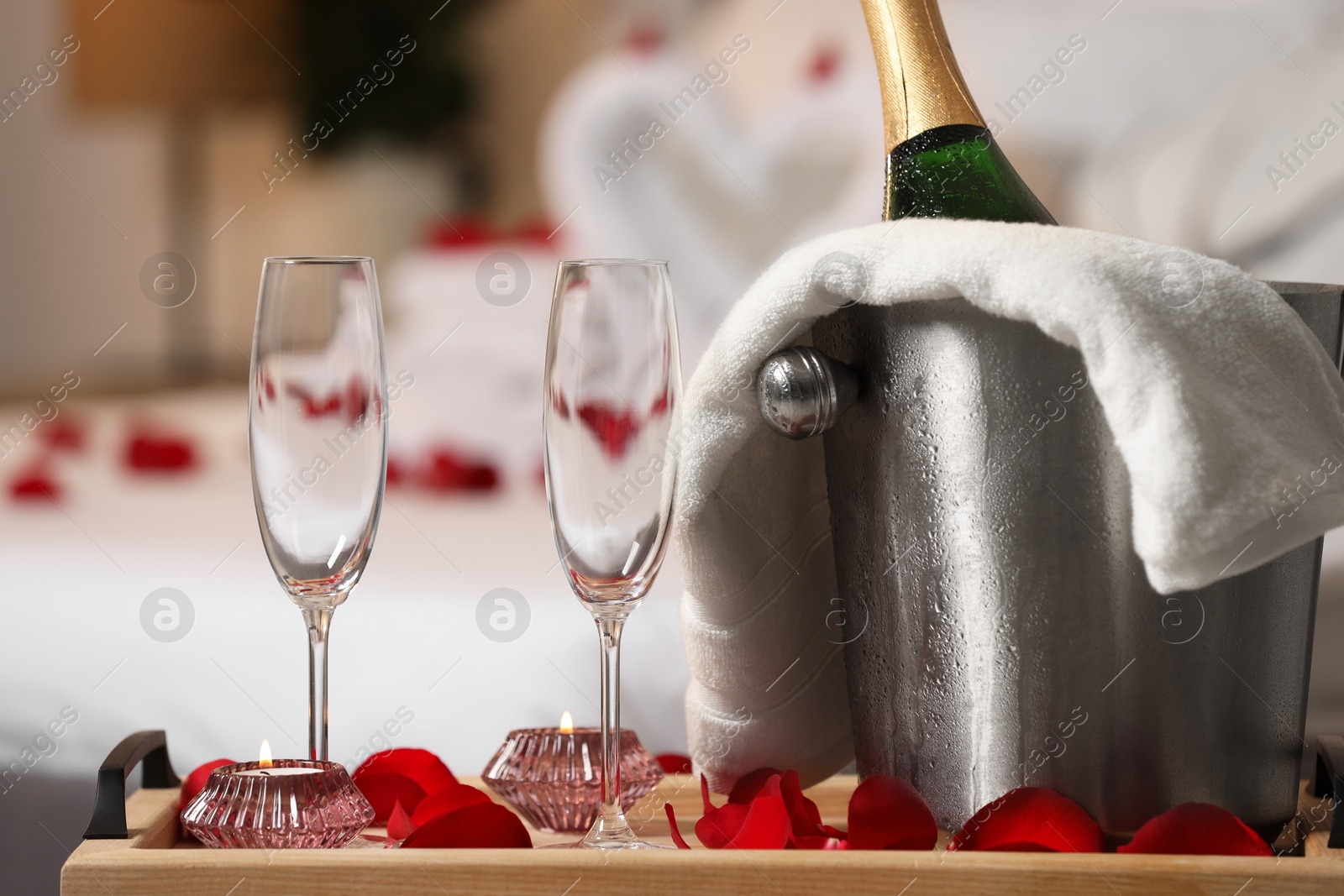 Photo of Honeymoon. Sparkling wine and glasses on wooden table in room