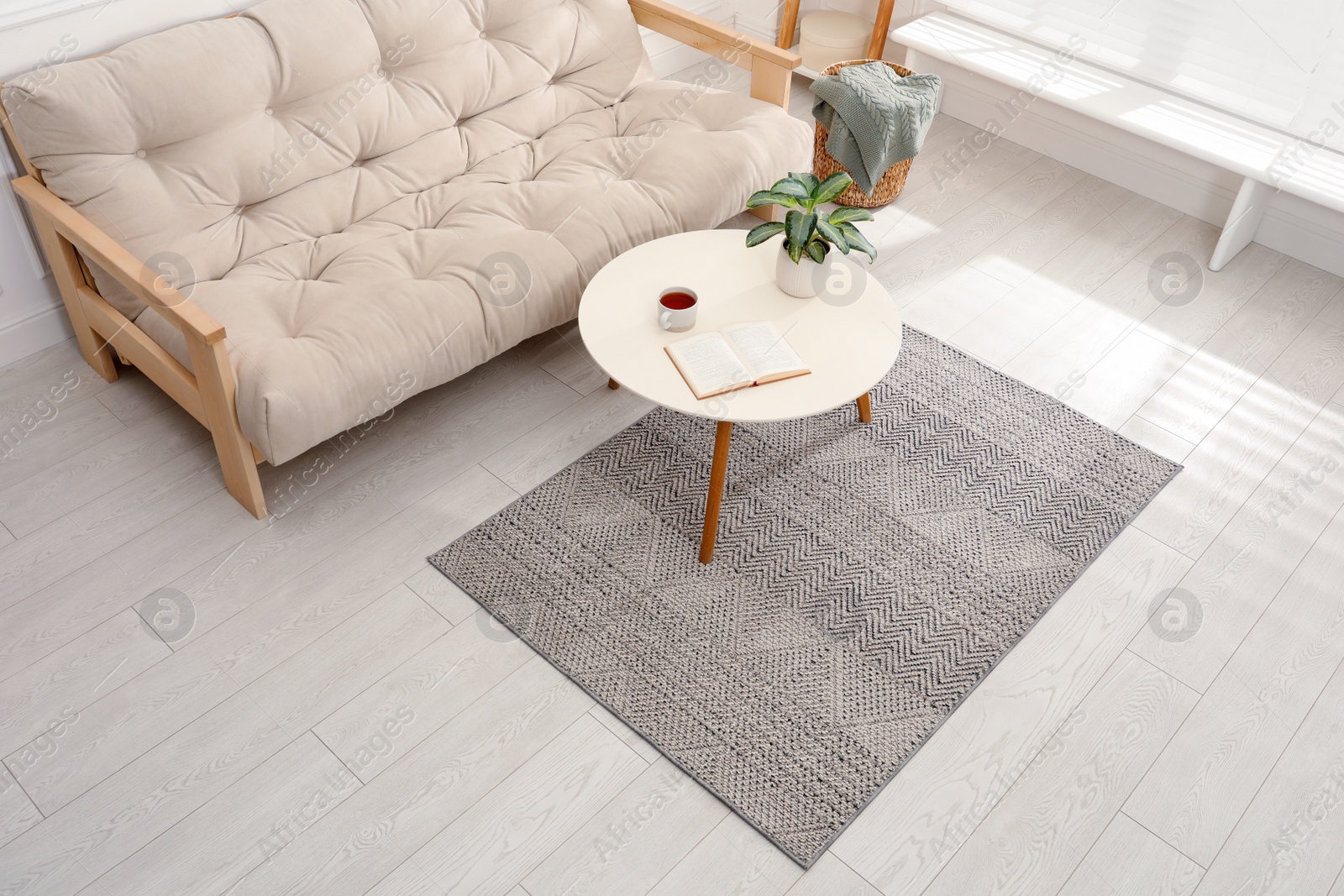 Photo of Stylish rug with pattern and table on floor in living room, above view