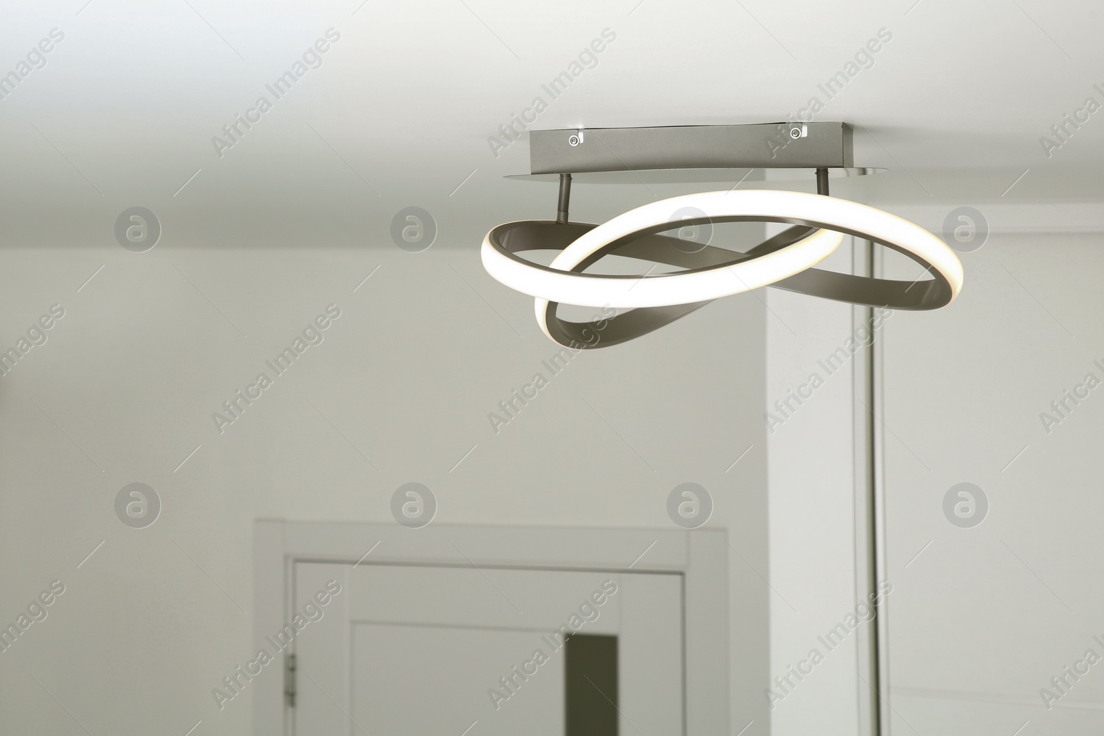 Photo of White ceiling with stylish lamp in room. Space for text