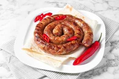 Delicious homemade sausage with chili pepper and lavash on white marble table