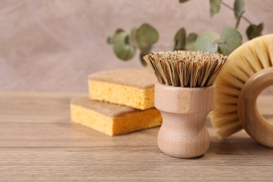 Photo of Small cleaning brush on wooden table, closeup. Space for text