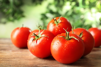 Fresh ripe tomatoes on wooden table, closeup