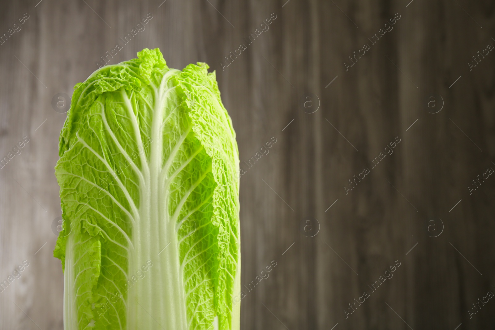 Photo of Fresh ripe Chinese cabbage against blurred background, closeup. Space for text