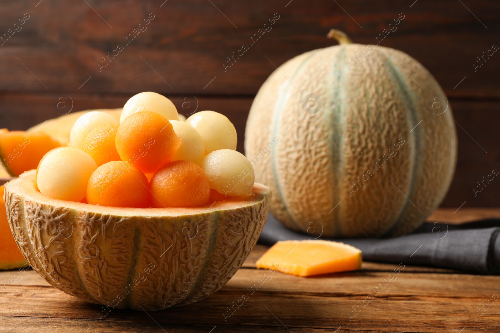 Photo of Different melon balls on wooden table. Space for text