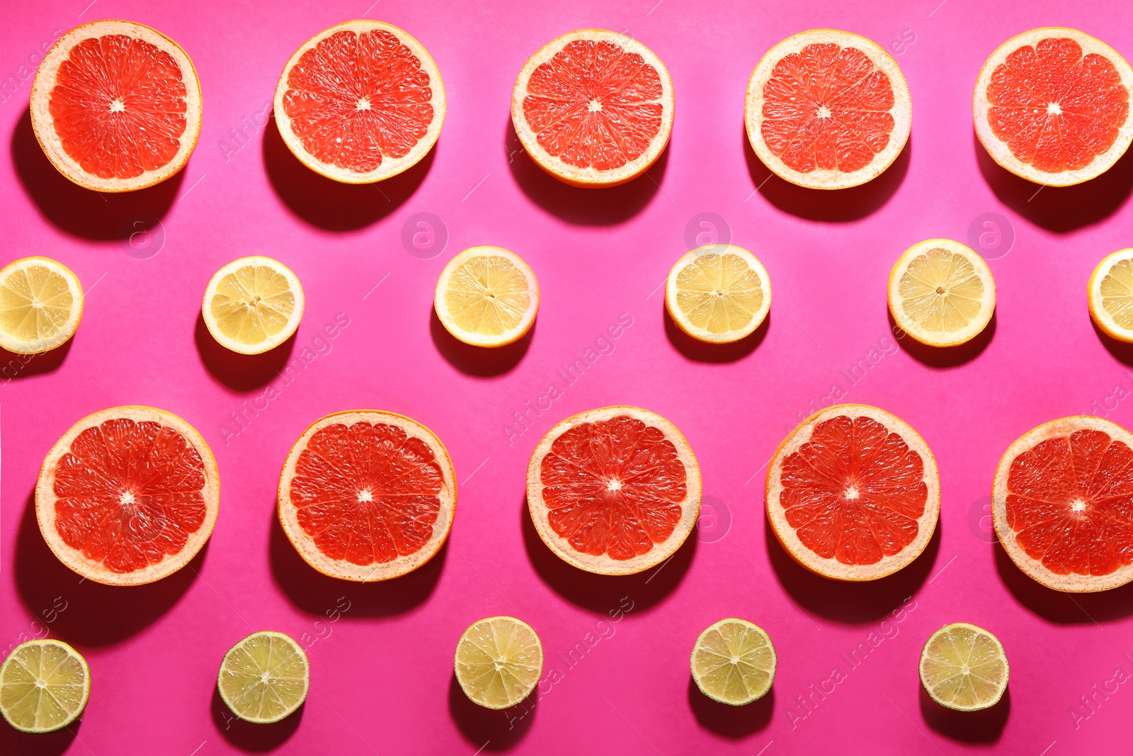 Photo of Flat lay composition with tasty ripe grapefruit slices on magenta background