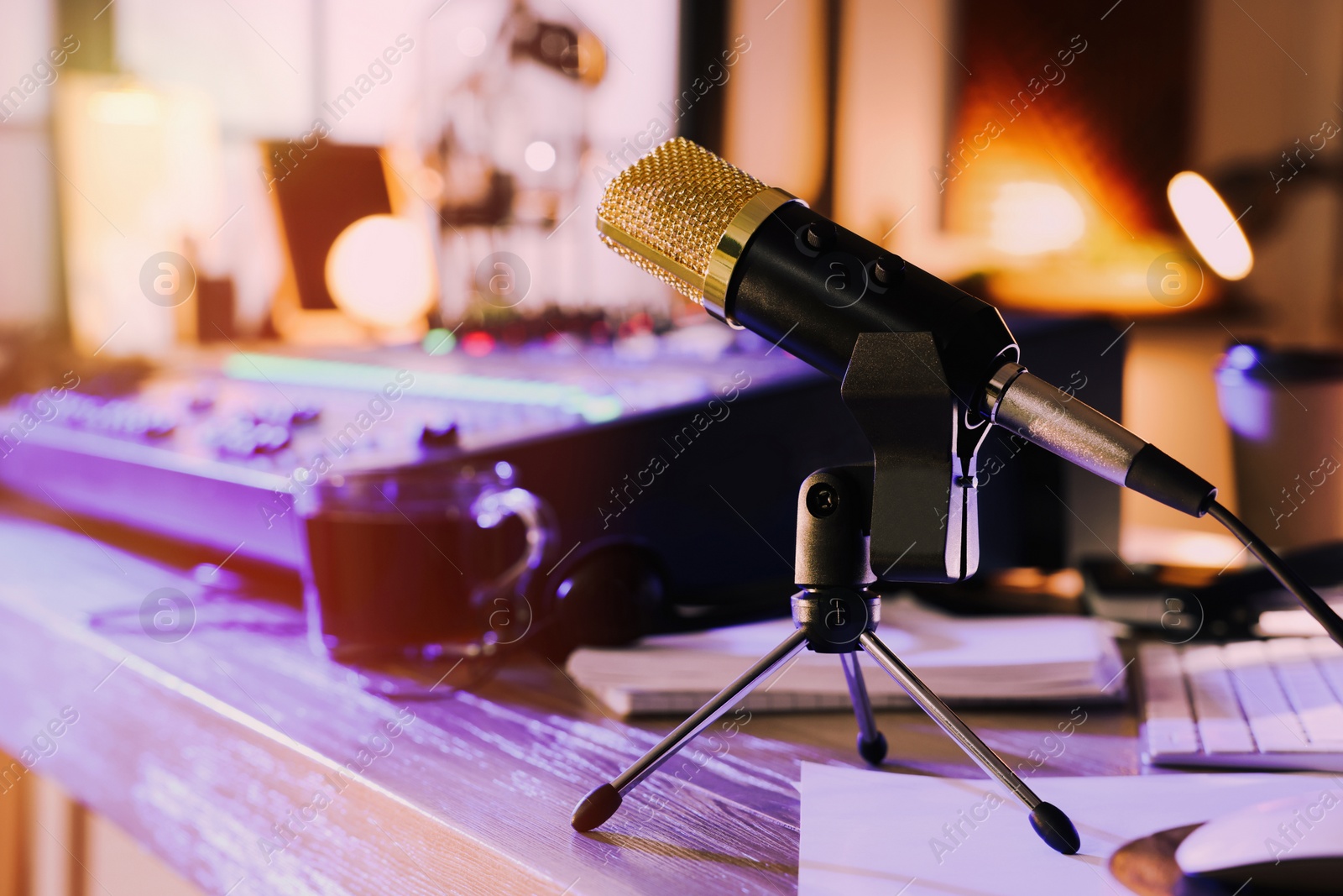 Photo of Microphone near professional mixing console on table in radio studio