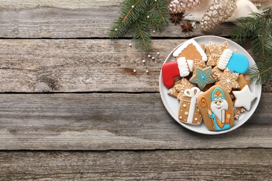 Photo of Tasty gingerbread cookies and festive decor on wooden table, top view with space for text. St. Nicholas Day celebration