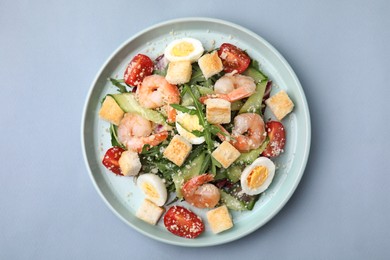 Photo of Delicious Caesar salad with shrimps on grey background, top view