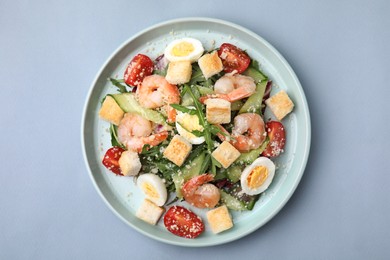 Delicious Caesar salad with shrimps on grey background, top view