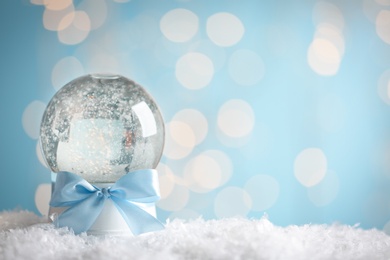 Photo of Beautiful snow globe against with Christmas festive lights. Space for text