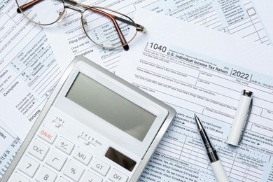 Photo of Calculator, glasses and pen on documents, flat lay. Tax accounting