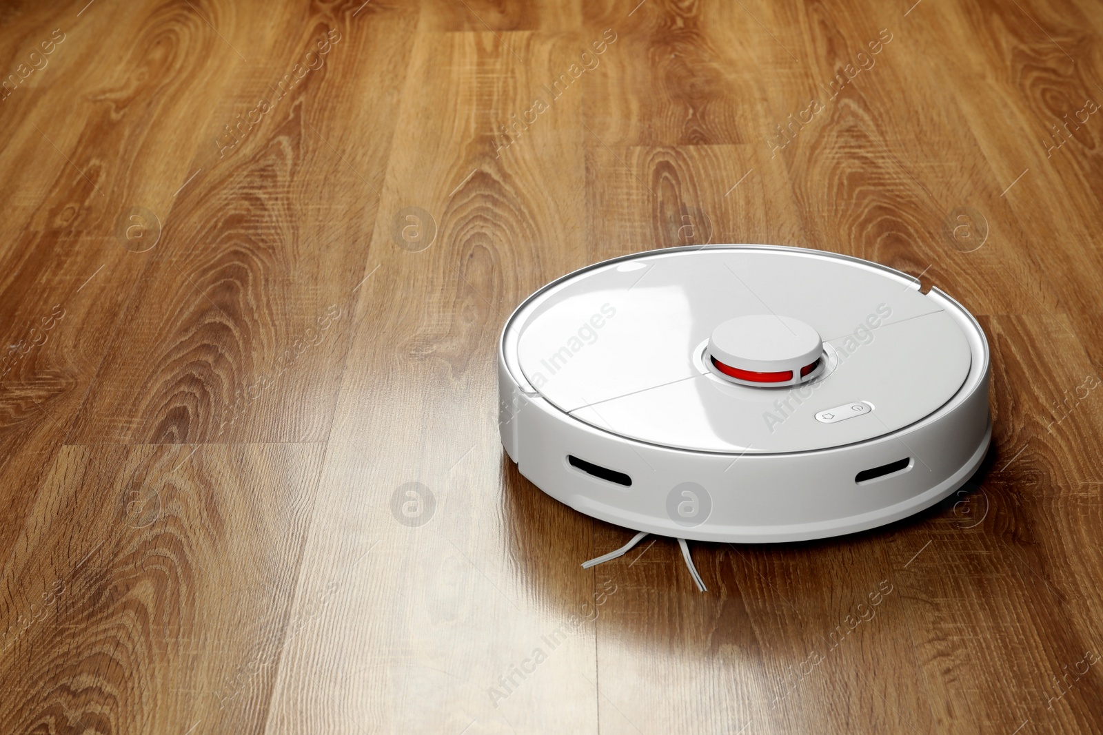 Photo of Robotic vacuum cleaner on wooden floor, space for text