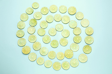Juicy fresh lime slices on light blue background, flat lay