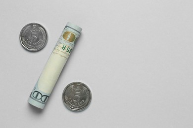 Photo of Percent sign made of Ukrainian hryvnia coins and United States dollar on light background, flat lay. Space for text