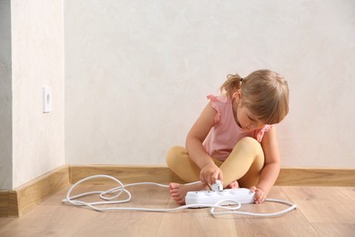 Little child playing with power strip at home. Dangerous situation