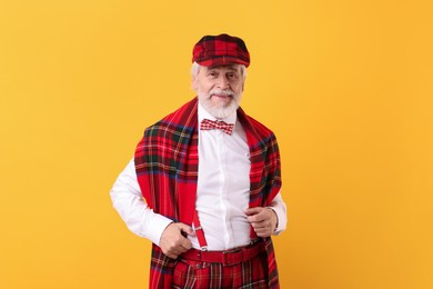 Photo of Portrait of grandpa with stylish hat and bowtie on yellow background