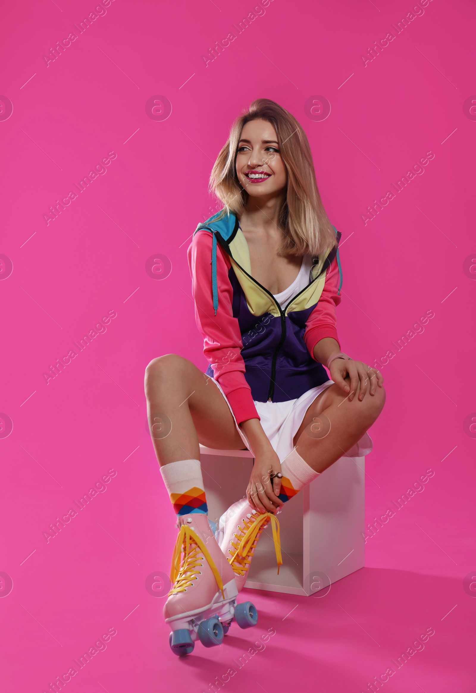 Photo of Young woman with retro roller skates on color background